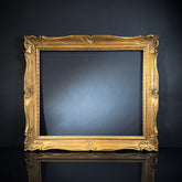 A large ornate carved gilt wood French vintage picture frame without a backing, displayed against a dark background.